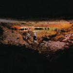 Two biologists survey a newly discovered cave 60 feet underground.
